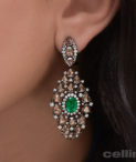 emerald drop earrings on woman's ear