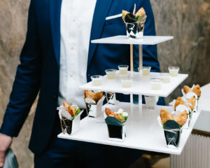 Spicy chicken â€œfortune cookieâ€ in crisp wontons, served in mini takeout boxes with ginger sake shots, by Peter Callahan Catering